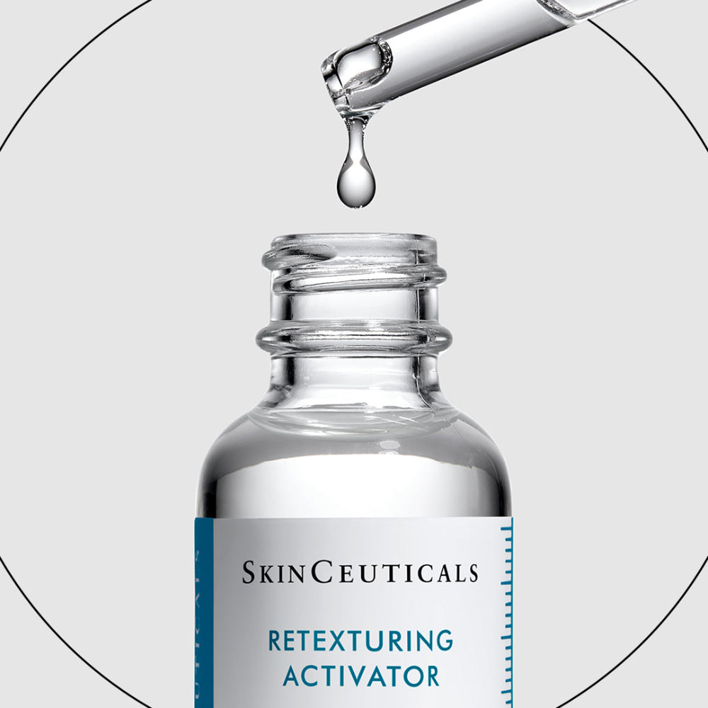 A close-up of a clear glass skincare dropper bottle with a white label reading SkinCeuticals Retexturing Activator, shown with a glass pipette dropping liquid above the open bottle on a light gray background.
