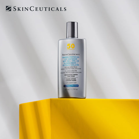 SkinCeuticals Shock Physical SPF 50 Sunscreen in a silver bottle with a metallic cap, displayed on a bright yellow pedestal against a light gray background with soft shadows.