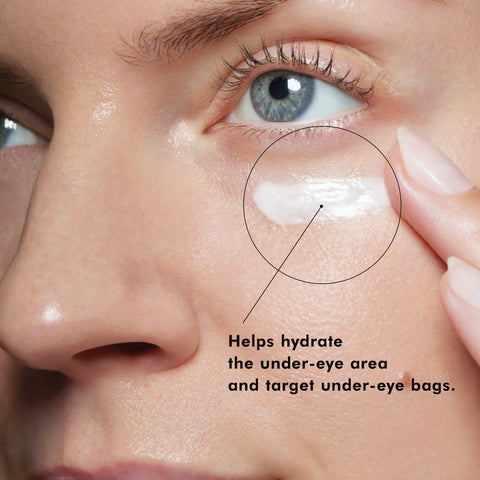 Close-up of a person applying SkinCeuticals Eye Balm under their eye with text indicating it hydrates and targets under-eye bags.