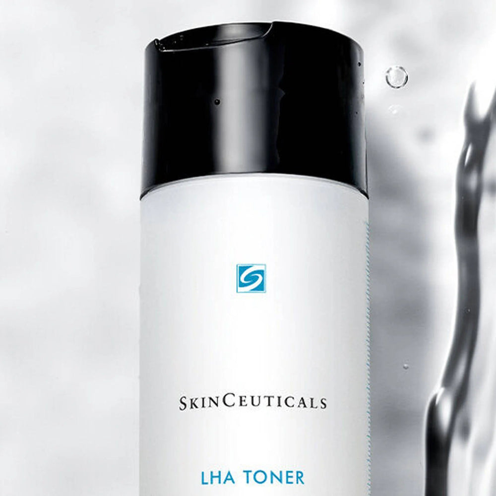 SkinCeuticals LHA Toner bottle with a white body and black cap, shown against a water-themed background with ripples and bubbles.