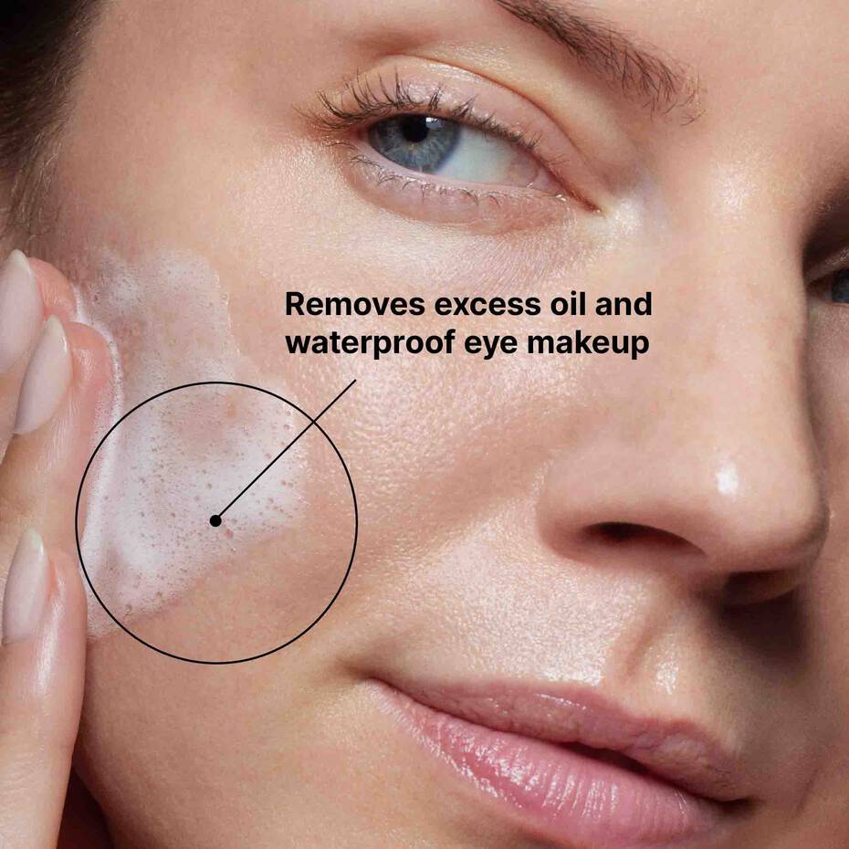 Close-up of a person's face with text indicating SkinCeuticals Simply Clean cleanser use for removing oil and waterproof makeup.